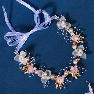 Detail of bridal headband with handmade white flowers, gold leaves and lavender ribbon