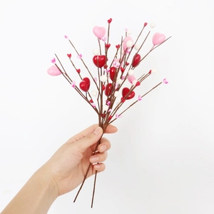 Détail d'une tige de baies artificielle avec des cœurs décoratifs rouges roses et blancs