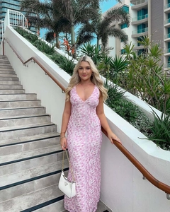 Detail of the deep V-neck and pink floral pattern on a slim-fit satin dress for vacations
