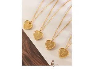 Gros plan détaillé de quatre pendentifs cœur avec gravure Love You More et bord perlé