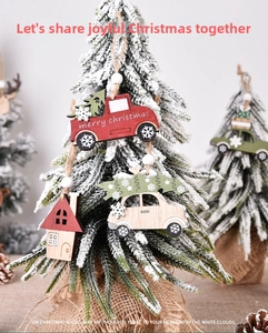 Detail of laser-cut wooden Christmas ornaments with truck and cottage designs on tree