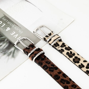 Leopard print women's belt with silver double ring buckle on magazine background