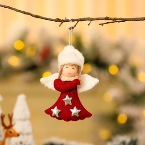 Christmas angel ornament with red skirt and white wings hanging on a festive tree branch