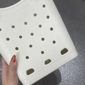 Macro shot of off-white EVA material bag showing waterproof circular vent holes