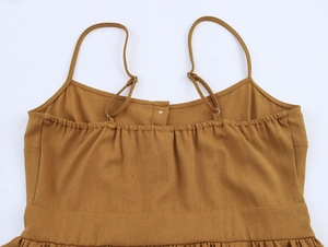 Détails des bretelles réglables et du dos élastique plissé sur robe marron en lin