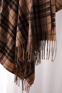 Macro view of brown and beige plaid cashmere-like scarf with soft woven tassels