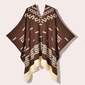 Detail of western-style knitted poncho with Aztec patterns and decorative fringe hem