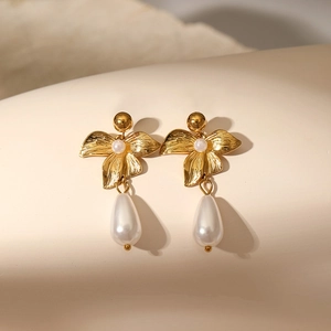 Detailed view of gold flower earrings with hammer texture and waterdrop pearls