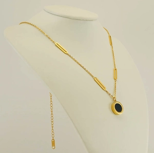 Close-up of gold 18k necklace with black round pendant and hollow rectangular links