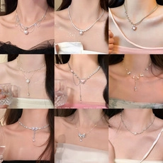 Collage of diverse silver necklaces featuring pearls, bows, hearts and tassel details