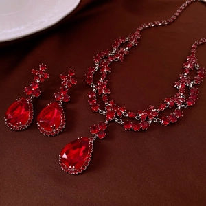 Détail d'un ensemble collier et boucles d'oreilles argent avec zircons rouges en goutte