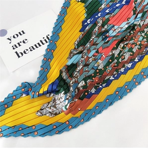 Macro detail of multicolored pleated silk scarf with floral patterns and zigzag edges
