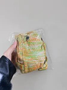 Bulk pack of green and orange knitted crocodile socks in a box showing premium texture
