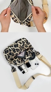 Detail view of leopard print crossbody bag showing spacious interior with makeup storage