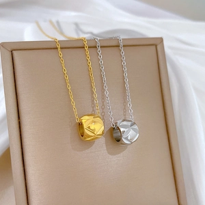 Detailed macro view of gold and silver cylinder pendants with diamond texture pattern