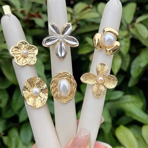 Close-up of vintage 18K gold plated pearl rings featuring flower and sunburst designs
