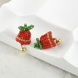Detailed view of handmade beaded strawberry earrings with gold bells for DIY jewelry