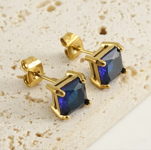 Gros plan de boucles d'oreilles carrées en zircon bleu foncé avec griffes dorées