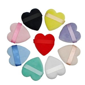 Set of 9 colorful heart-shaped velvet powder puffs with ribbon handles in a circular layout