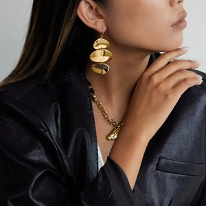 Boucles d'oreilles géométriques dorées à trois niveaux avec finition miroir sur mannequin