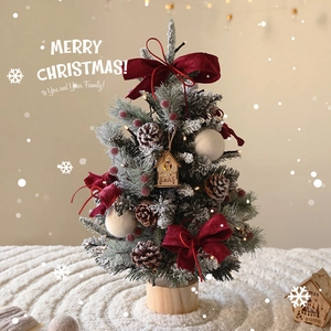 Mini flocked cedar desktop Christmas tree with red bows and glowing wood house ornament