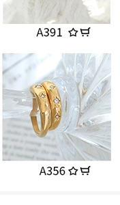 Detail of 18K gold plated titanium rings with starburst zircon inlay on a glass bottle