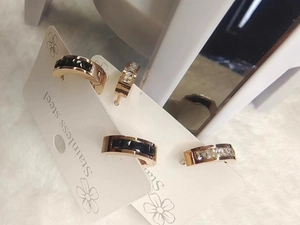 Detail of rose gold stainless steel earrings with black square and clear round stones