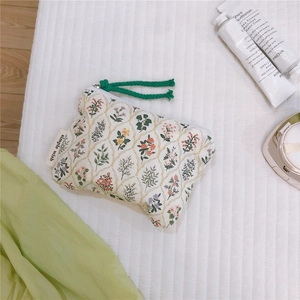 Macro shot of cotton floral coin purse with green zipper pull and simple wish label