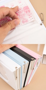 Detail showing the card insertion process and four colors of mini photo albums with chains