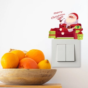 Detailed Christmas wall sticker showing Santa Claus on a light switch with festive fruit decor