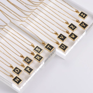 Gold plated square initial necklaces from N to Z displayed on acrylic stands