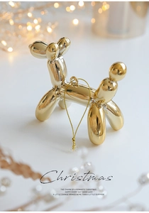 Detail view of mirror-finish gold balloon dog ornament with festive hanging string