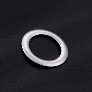 Polished silver stainless steel round pendant accessory on black leather texture background