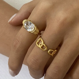 Macro view of gold plated stainless steel ring with oval rhinestone and chain link detail