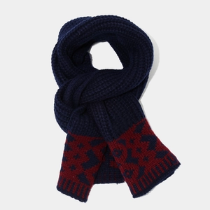 Close-up of thick navy blue knitted scarf with deep red jacquard snowflake patterns