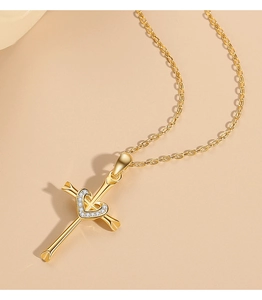 Detail of gold heart cross pendant necklace featuring white cubic zirconia stones