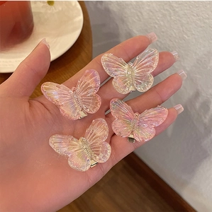 Detail of iridescent butterfly hair clips with textured finish and metal duckbill clips