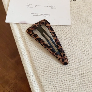 Dettaglio di un fermaglio per capelli BB con stampa leopardata su una carta decorativa