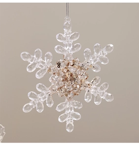 Detailed macro view of clear acrylic snowflake ornament with sparkling gold center beads