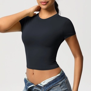 Detailed fit of black crew neck slim crop top yoga t-shirt on a model with denim jeans