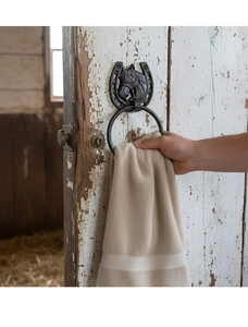 Detail of vintage cast iron horseshoe towel holder with horse head carving on barn door