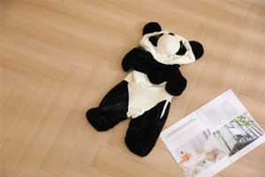 Barboteuse panda en peluche avec capuche posée à plat sur un parquet en bois