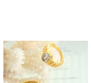 Macro detail of 18k gold plated ribbed ring with crystal inlay on a coral stand