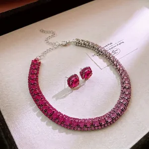 Schmuckset mit rosa Strasshalskette und Ohrringen für Damen auf beigem Hintergrund