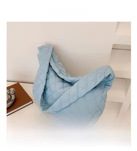 Detail of light blue quilted tote bag showing rhombus stitching and soft padded fabric
