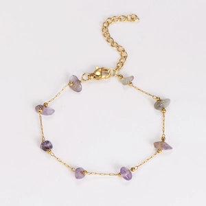 Detail view of a gold-plated stainless steel bracelet with natural purple crystal stones