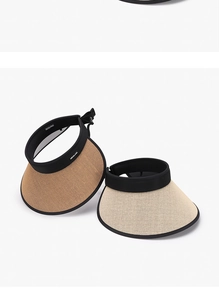Dettaglio di visiere parasole color cuoio e beige con nastri neri e trama intrecciata
