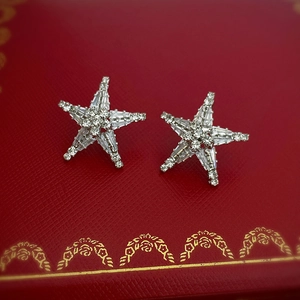 Macro view of rhinestone starfish earrings on a red textured jewelry gift box
