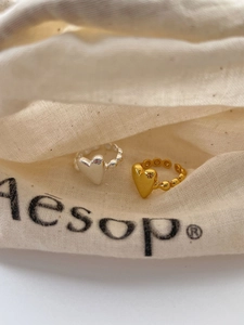 Close-up of golden and silver 925 sterling silver heart rings with beaded bands