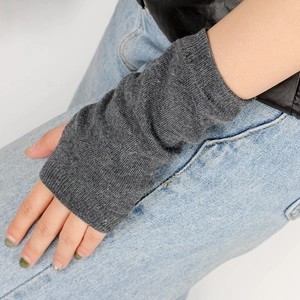 Close-up of dark grey knitted arm warmer with ribbed cuffs and fingerless thumb hole design